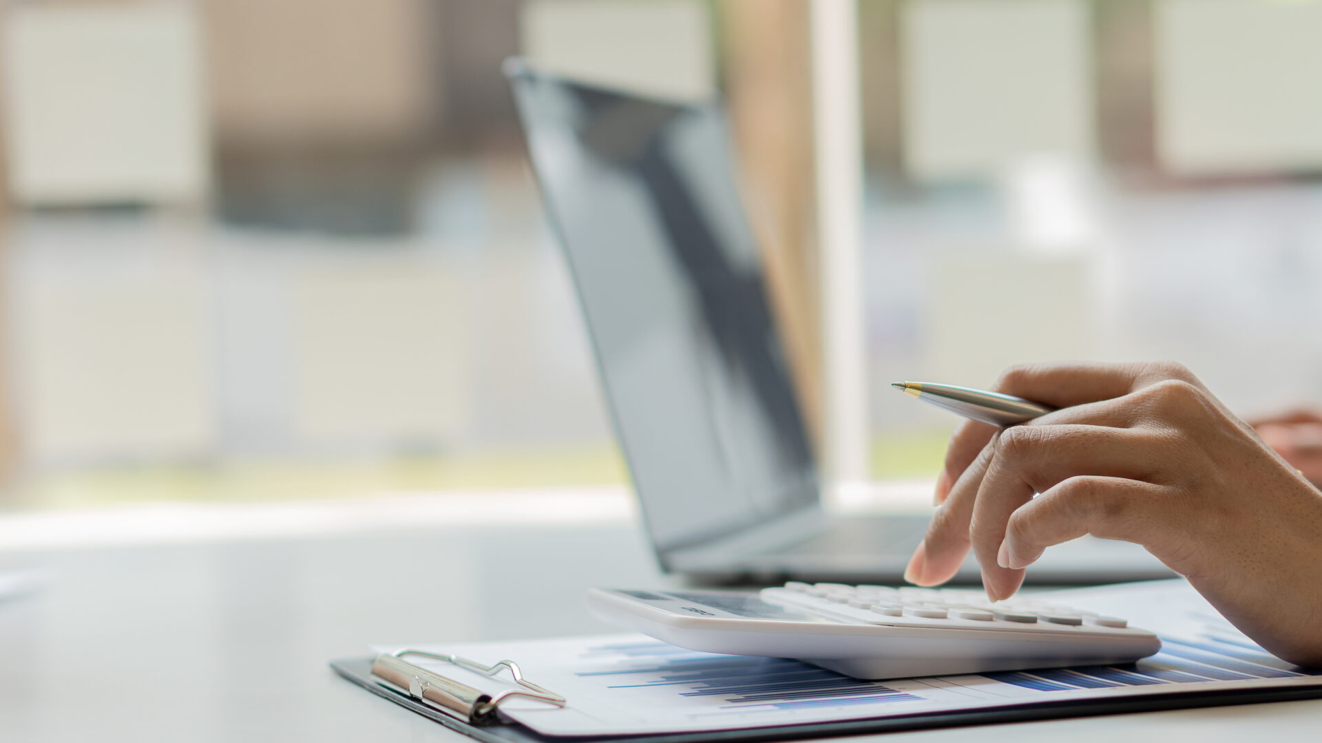 A Businessman Presses A White Calculator To Calculate Numbers In Company Financial Documents. The Finance Department Prepares Accounting Documents, Analyzing Income And Expenses In The Business.