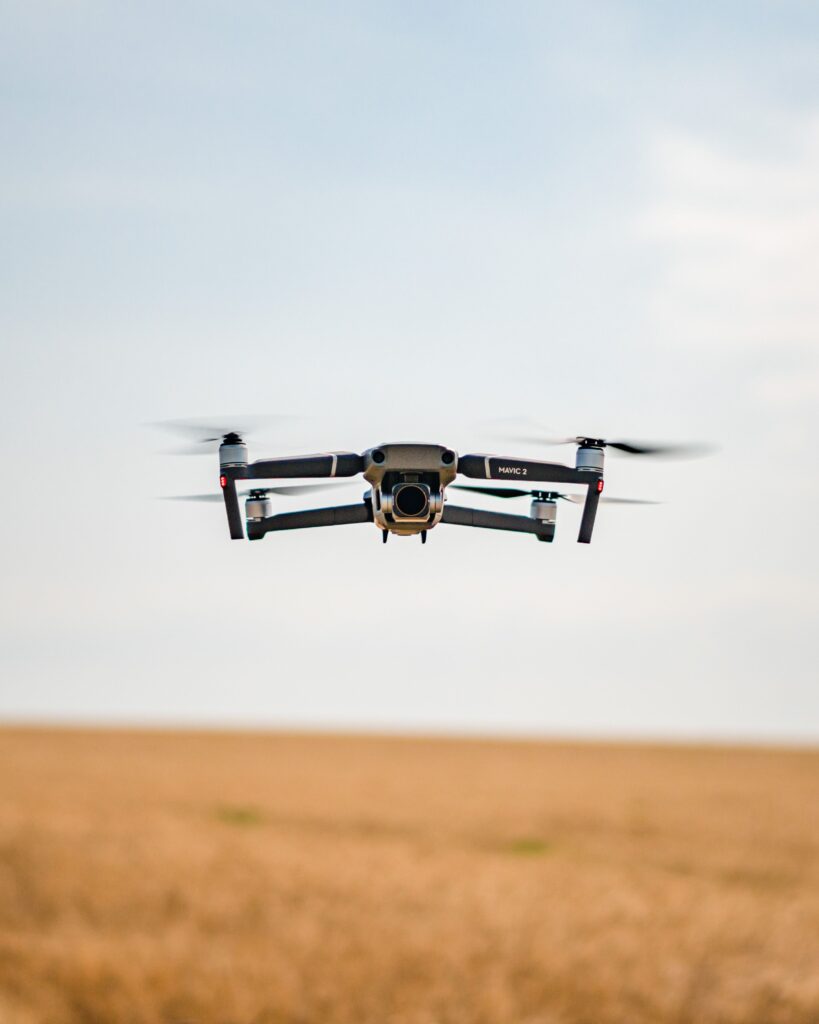 Modern Drone Takes Flight Over A Vast Expanse Of Golden Wheat, Highlighted By The Sun